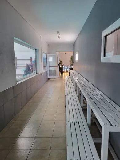 Pasillo de ingreso con bancos, antes de la intervención
