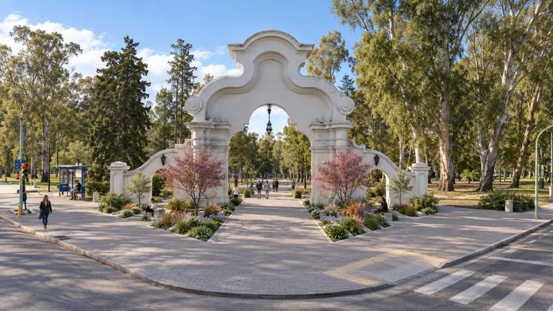 Ingreso Parque de Mayo — plaza seca con canteros y el portal restaurado