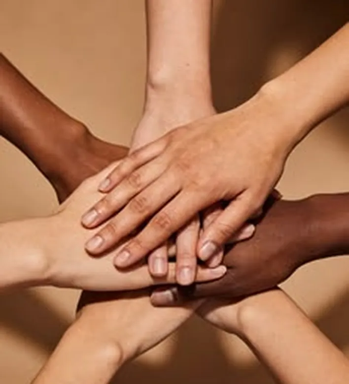Manos de distintos tonos de piel apoyadas unas sobre otras